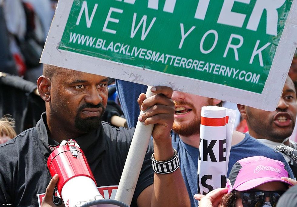 A Black Lives Matter New York demonstrator holds a sign to counter white nationalist demonstrators at the entrance to Lee Park