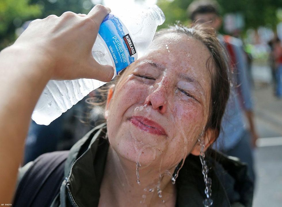 A counter demonstrator gets a splash of water after being hit by pepper spray