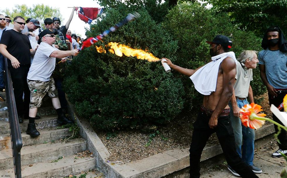A counter demonstrator uses a lighted spray can against white nationalist demonstrators.