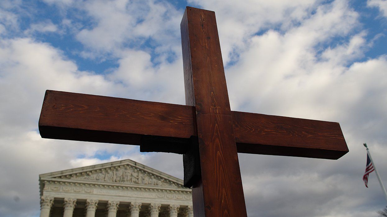 A cross is held aloft in from of the U.S. Supreme Court