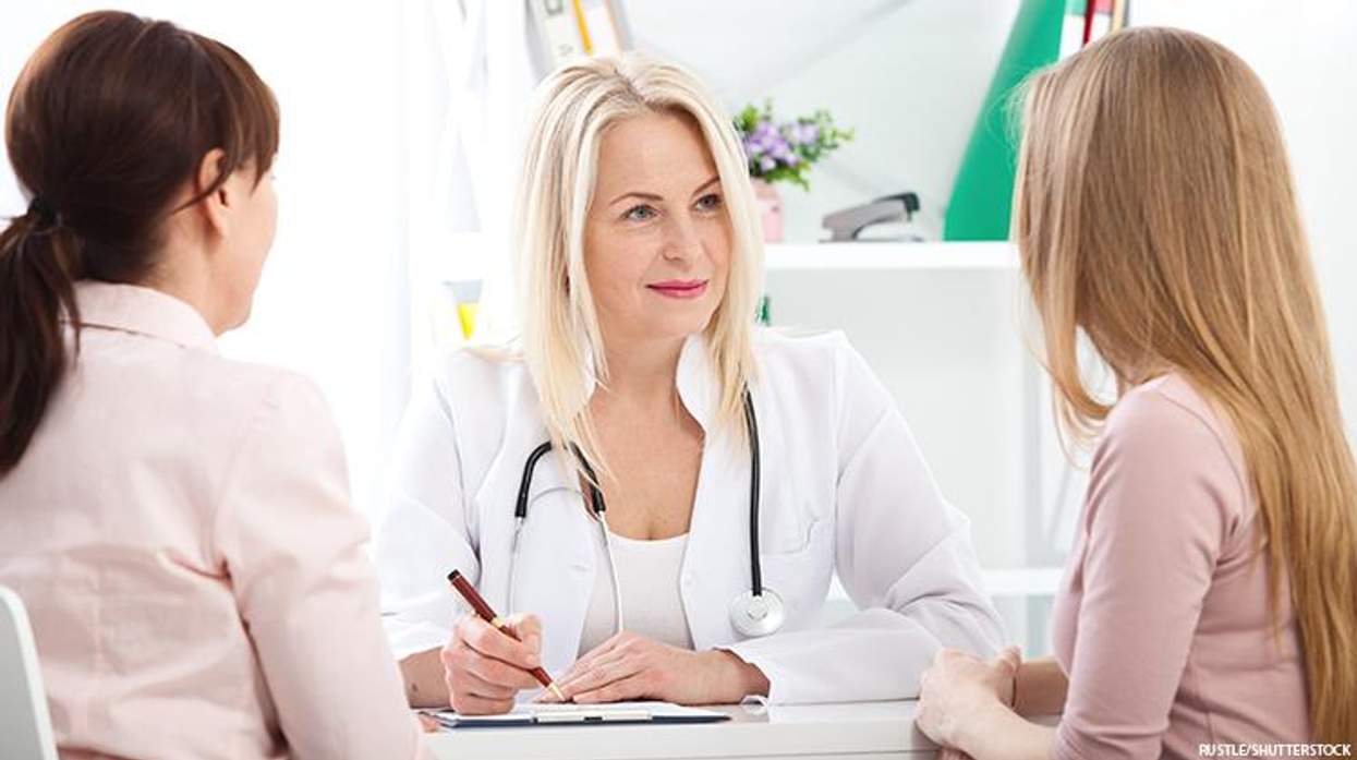 A doctor with long blond hair consults two patients each with long hair of darker shades.