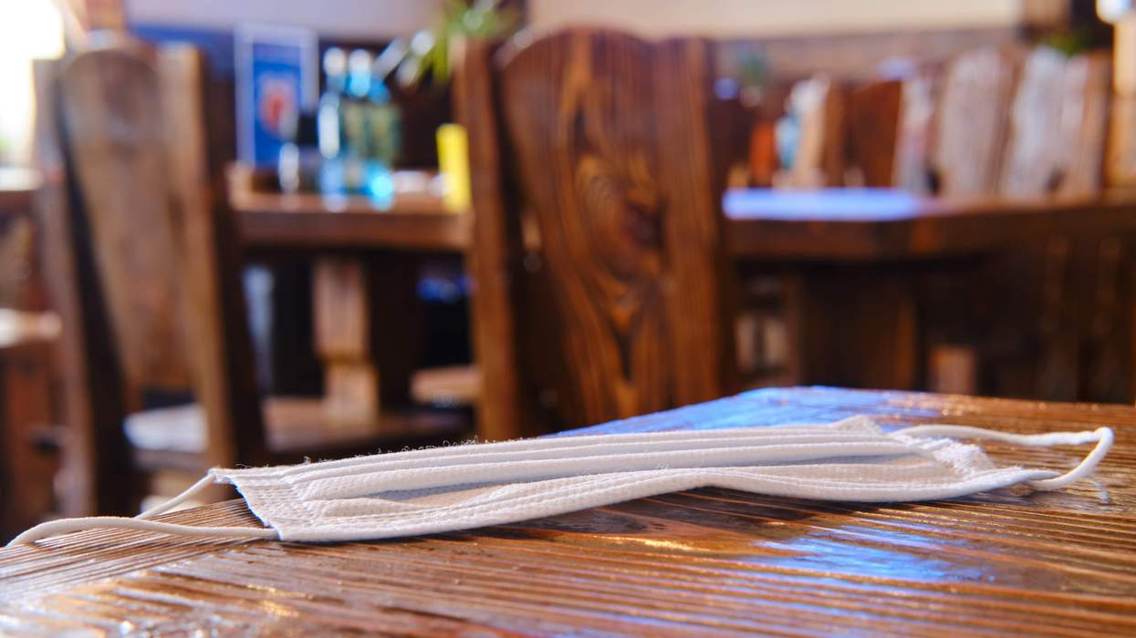 A face covering left on the table of a bar