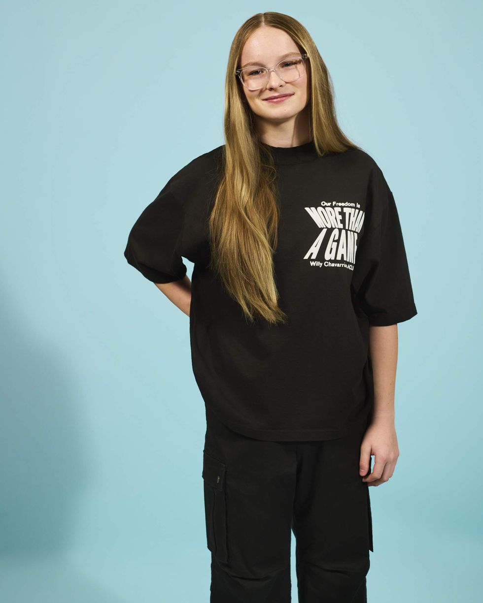 A girl in an all-black outfit with a t-shirt that says, "Our Freedom is More Than a Game"
