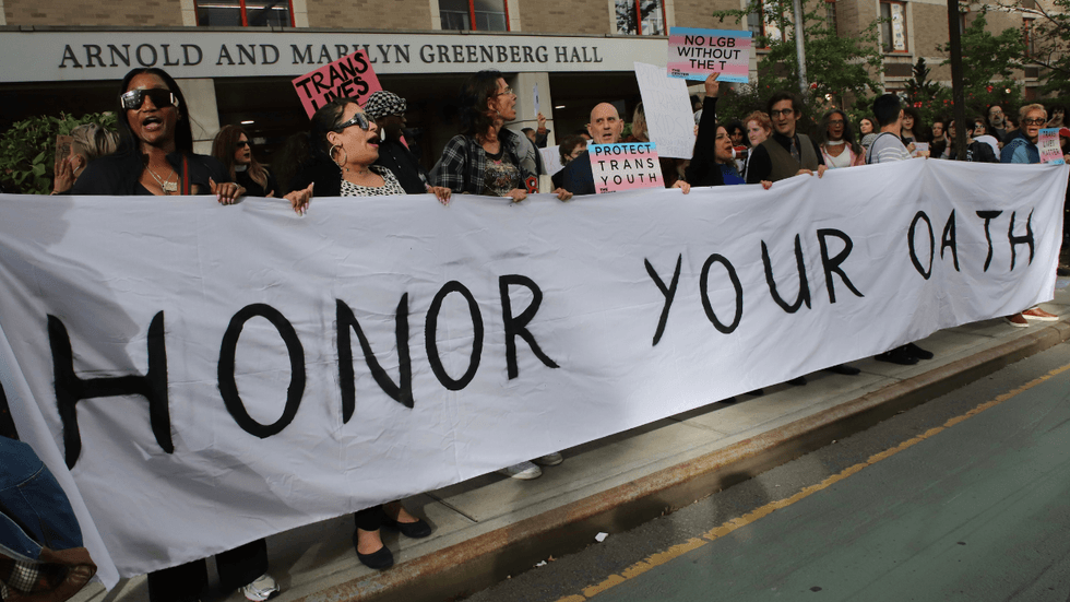 A group of protesters hold up a long banner that reads "Honor Your Oath."