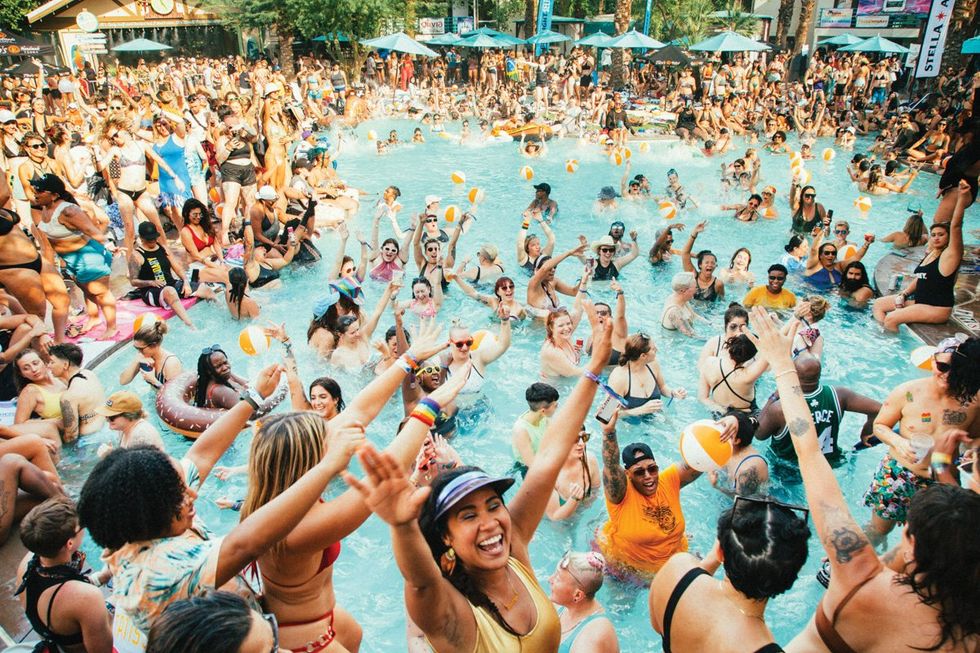 a large crowd of mostly queer women having fun in a pool in palm springs