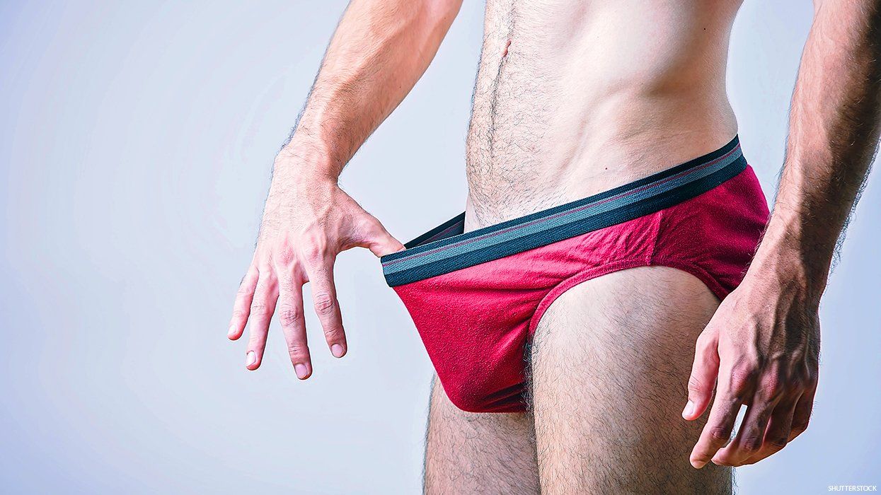 A man looking into the front of his own underwear.