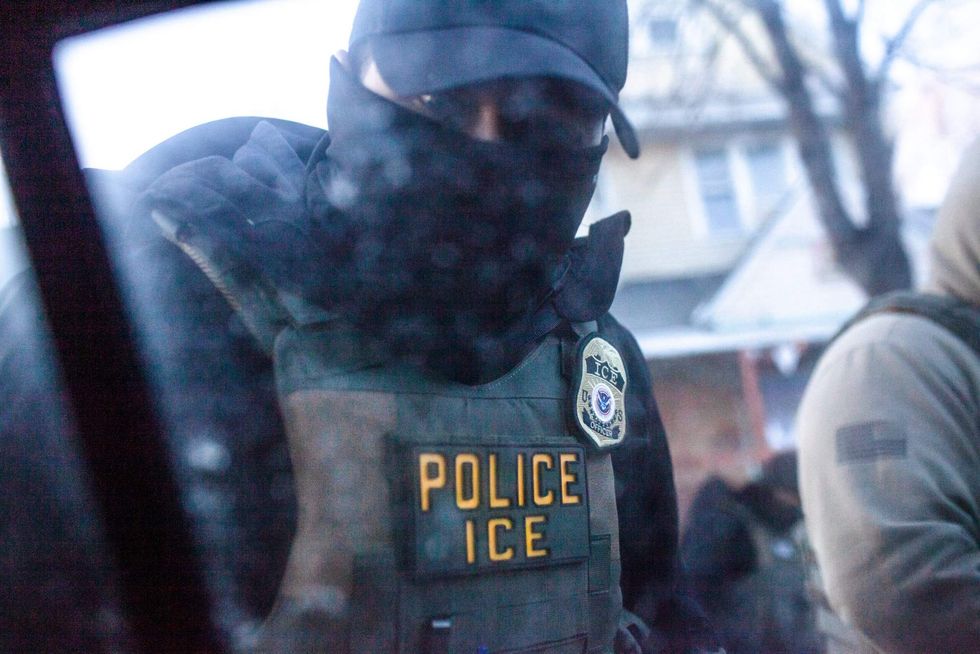 A masked ICE agent knocks on the window and tells Elle Neubauer and the other observer she was riding with to stop following ICE vehicles while on an early morning watch Monday, Jan. 12, 2026.