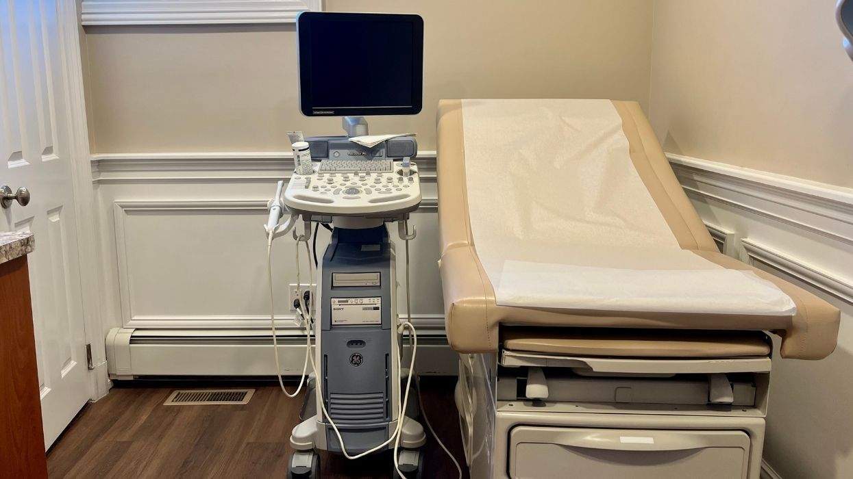 a medical treatment room with an ultra sound machine and a table