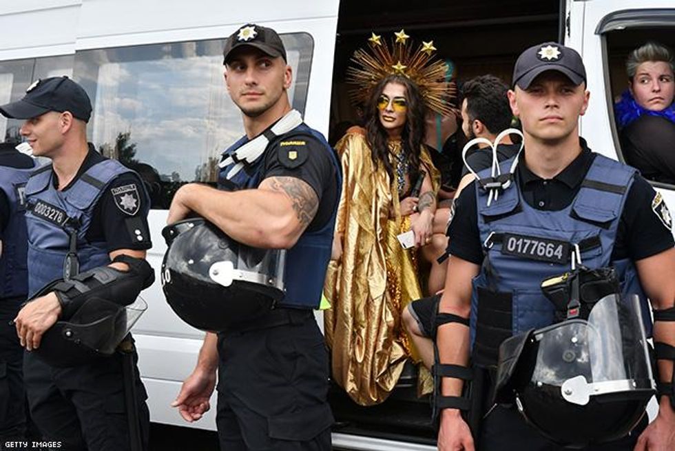 A participant looks around while sitting in a bus as policemen stand guard during the annual Gay Pride parade in Kiev
