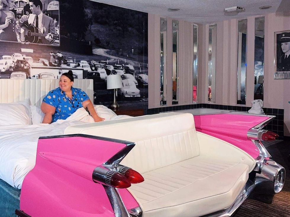 a person sitting in a pink cadillac bed
