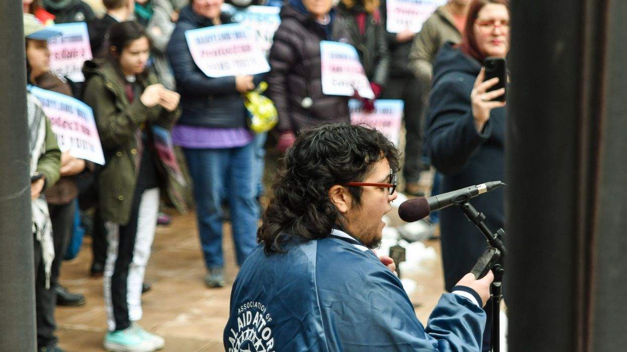 a person speaks before a crowd of supporters for trans rights
