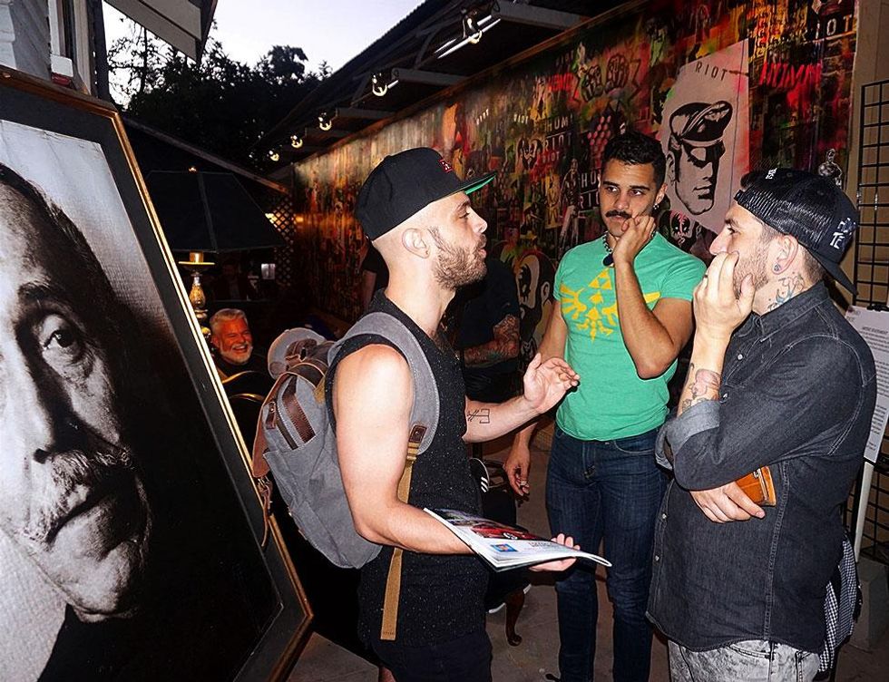 A portrait of Tom, at left, watches over the crowd.