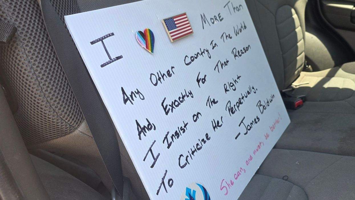 a protest sign that reads i love america more than any other country in the world and, exactly for that reason i insist on the right to criticize her perpetually - james baldwin - she can and must be better
