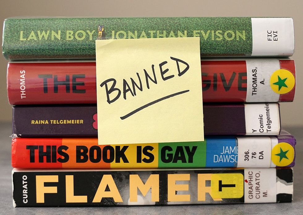 A stack of books found on frequently banned book lists labeled with a sticky note