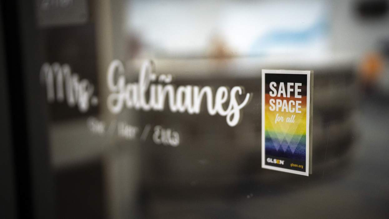 A sticker with a rainbow background reads "Safe space for all" and is displayed on a glass classroom door.