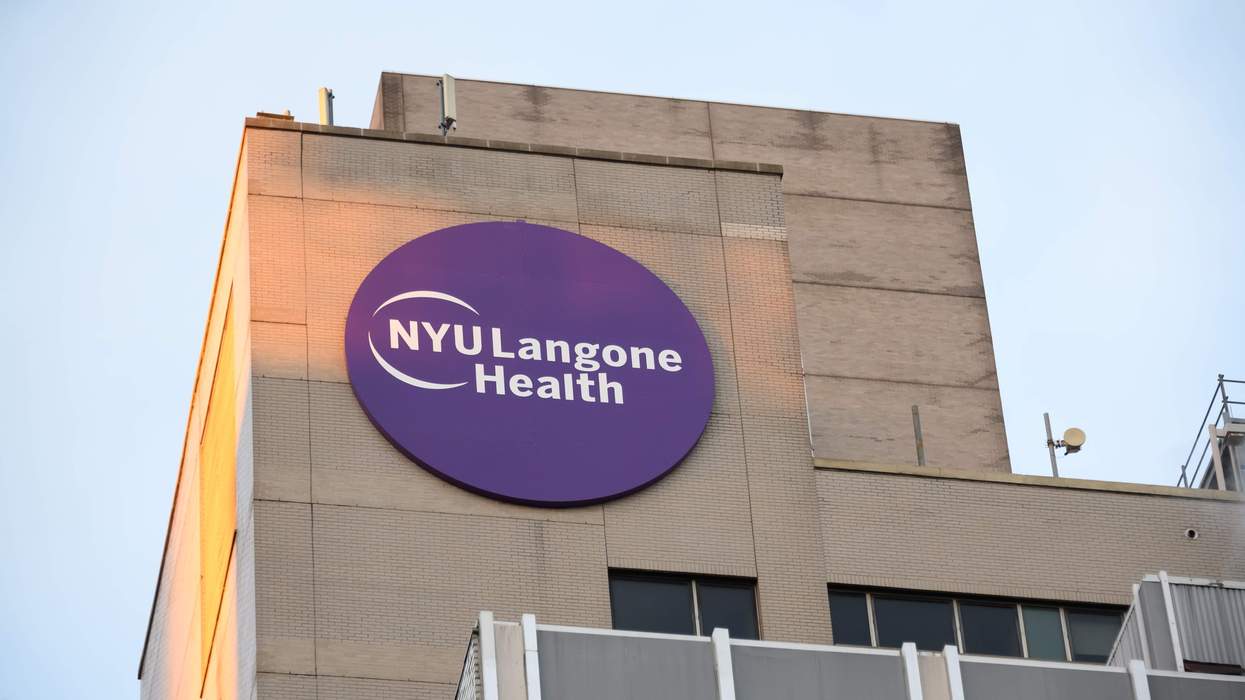 A tall, tan-colored building displays a circular purple logo that reads: "NYU Langone Health."