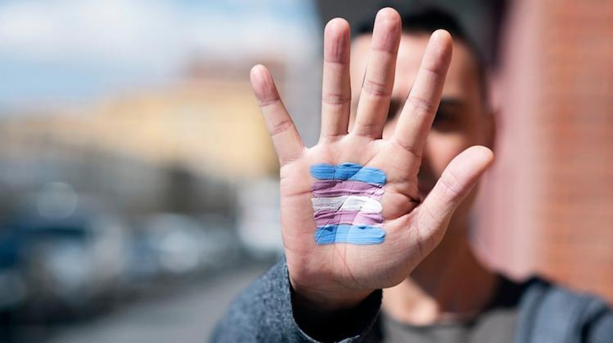 a trans person holding their hand up