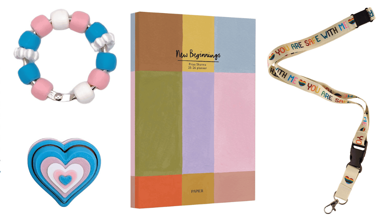 A transgender Pride fidget bracelet and heart, a colorful Papier planner, and a “You Are Safe With Me” Pride lanyard.