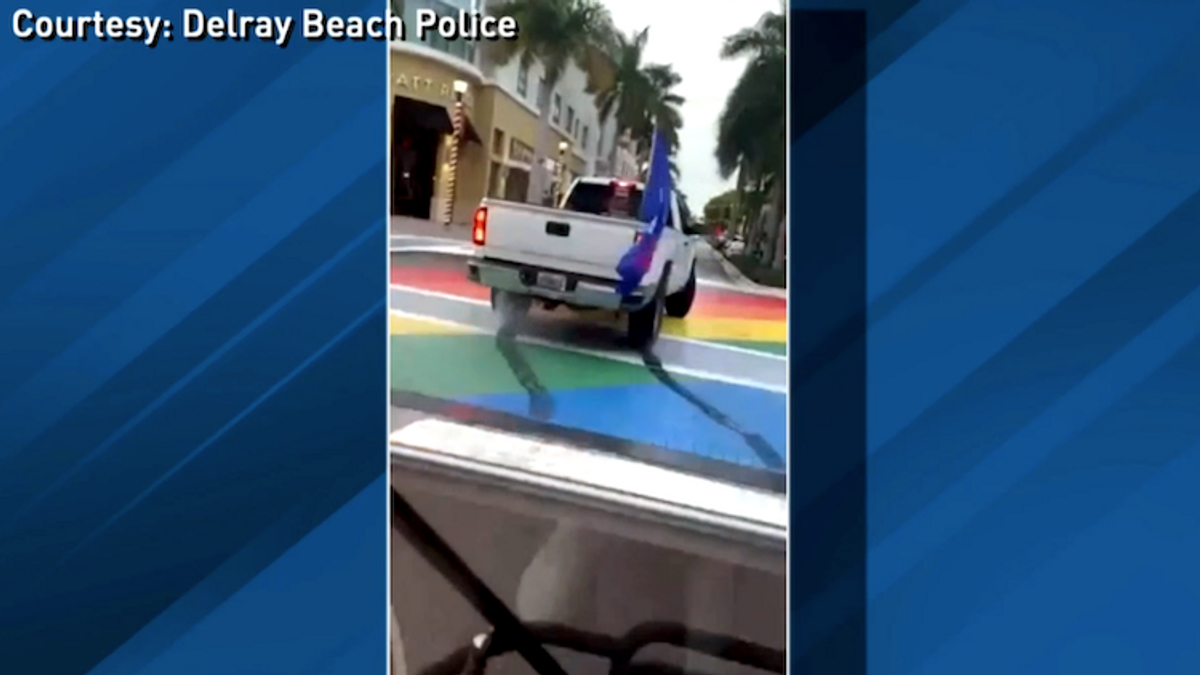 A truck doing a burnout over an LGBTQ-themed street painting