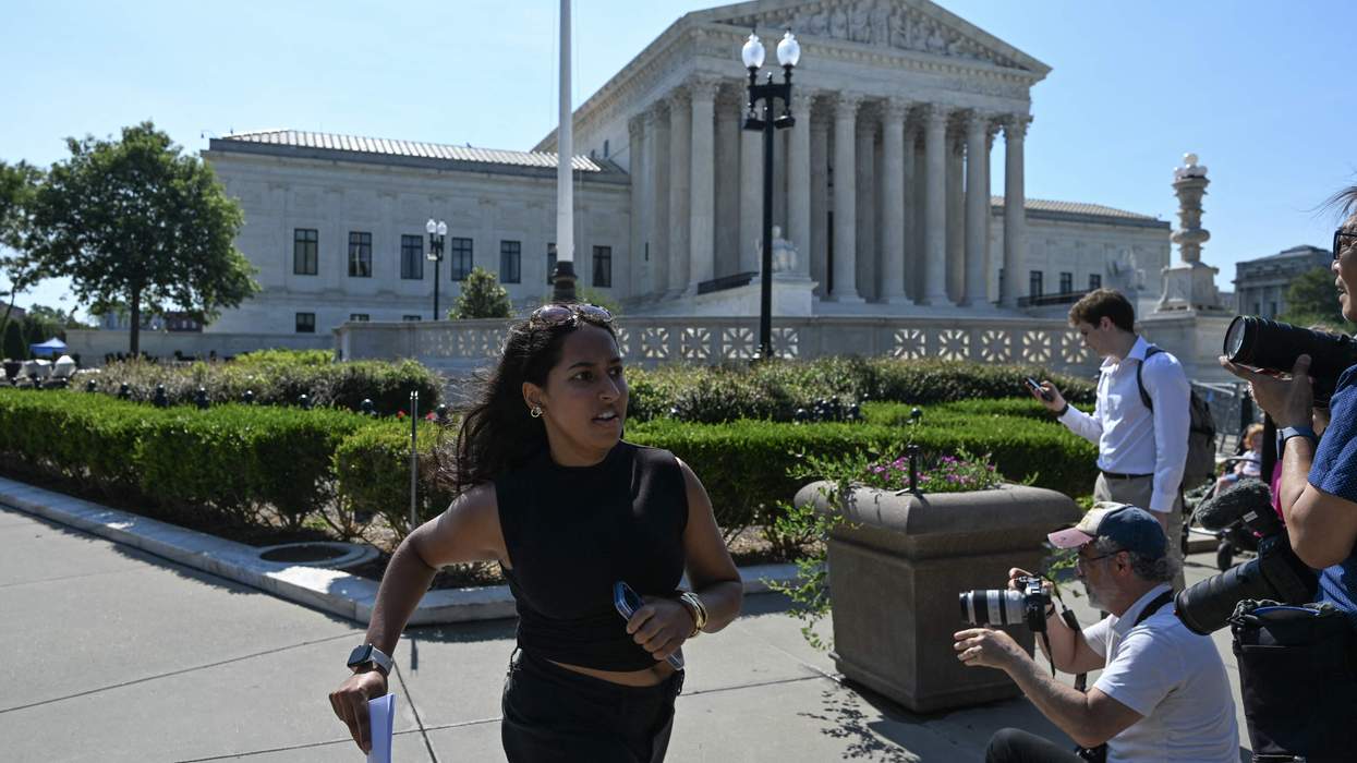 A U.S. Supreme Court intern runs to deliver copies of the Court's opinions to reporters after the Court upheld state laws barring transgender athletes from competing in girls' and women's school sports on June 30, 2026.