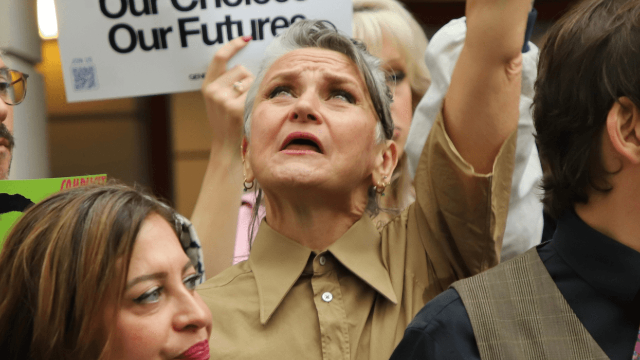 A woman appears to be overcome with emotion, looking upward in the crowd of a protest.