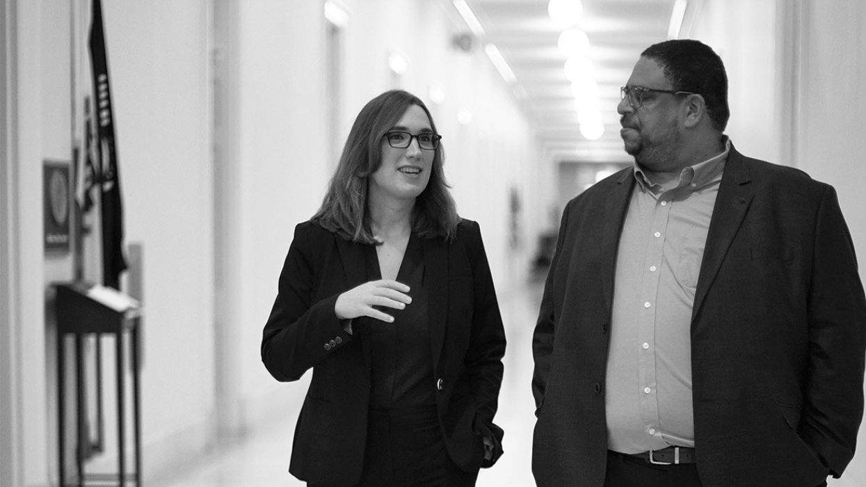a woman speaking with a man while walking the halls of Congress