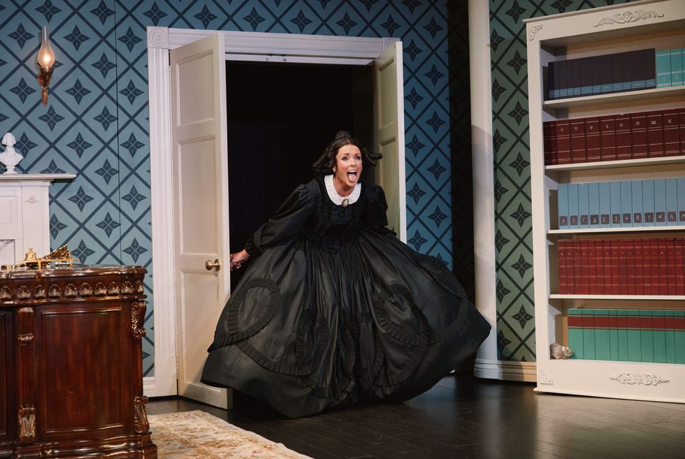 A woman sticking her tongue out as she's leaving through double doors