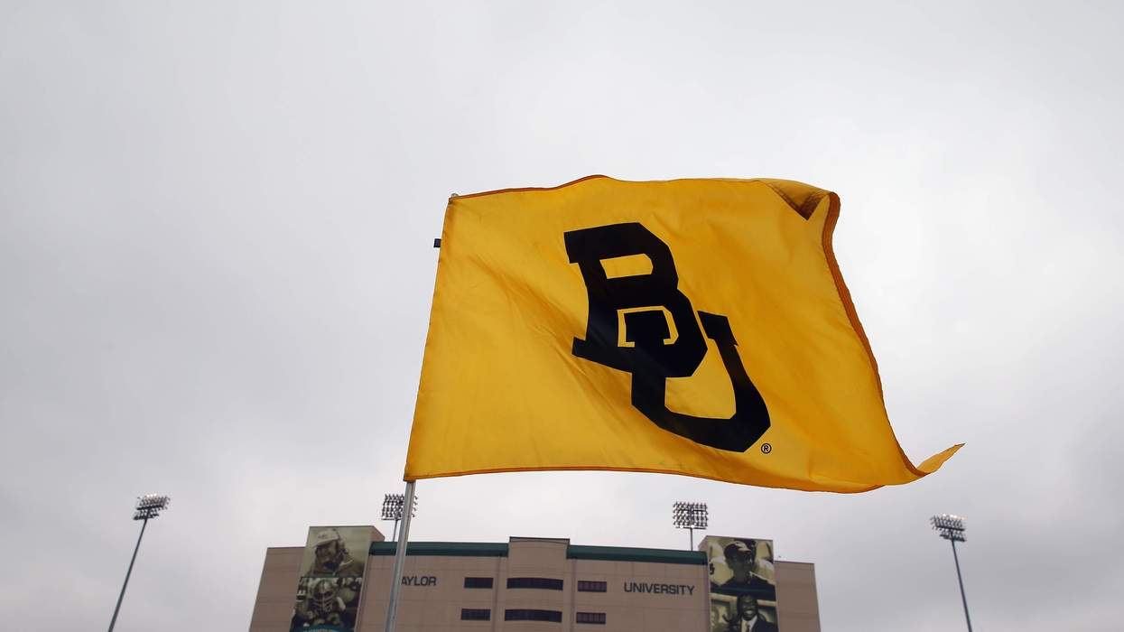 A yellow and black flag displaying the letters "BU" flies outside a sports arena labeled "Baylor University."