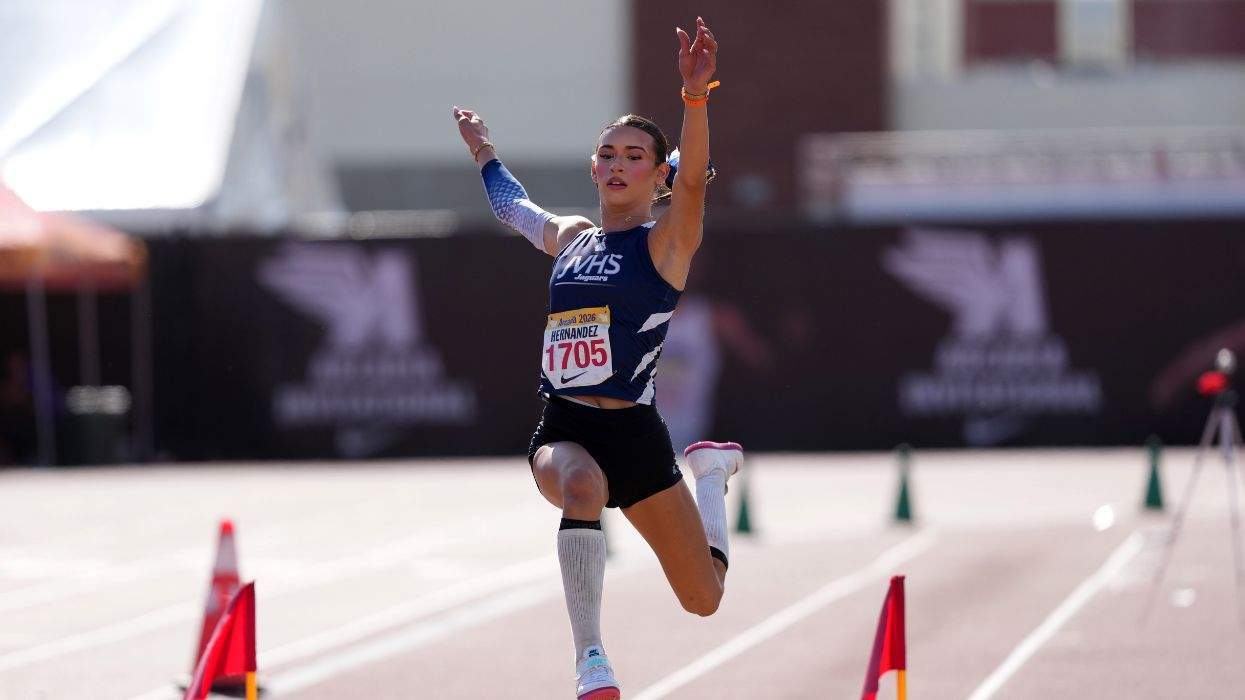 AB Hernandez mid-jump during a track and field event
