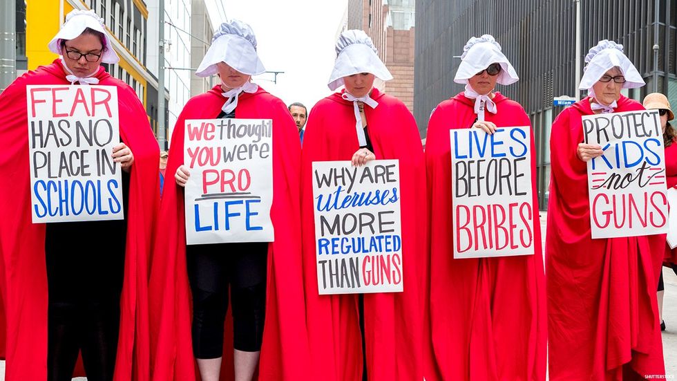 Activists in Handmaids Tale outfits