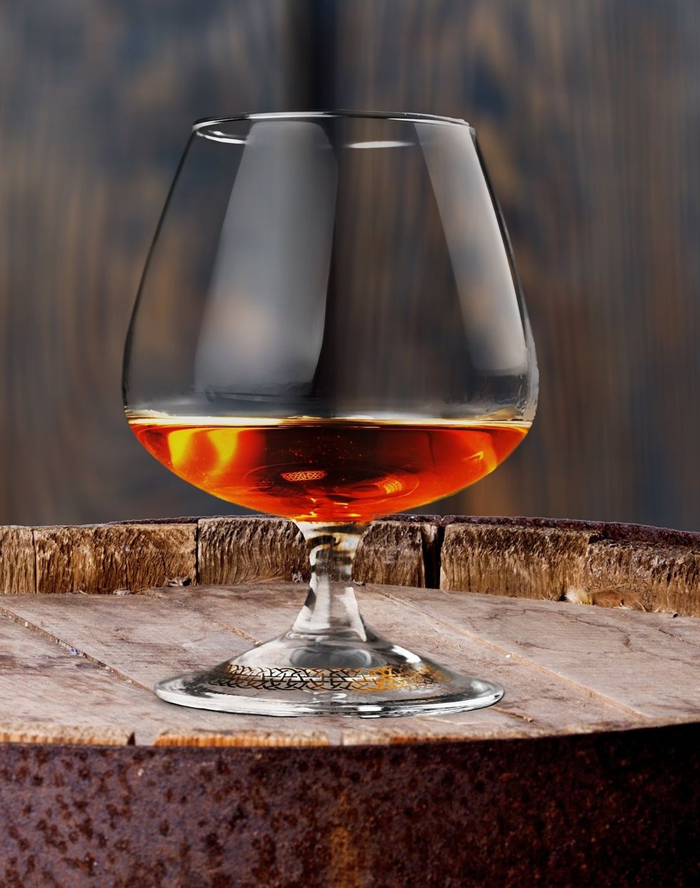 alcohol glass on barrel of cognac in wine cellar