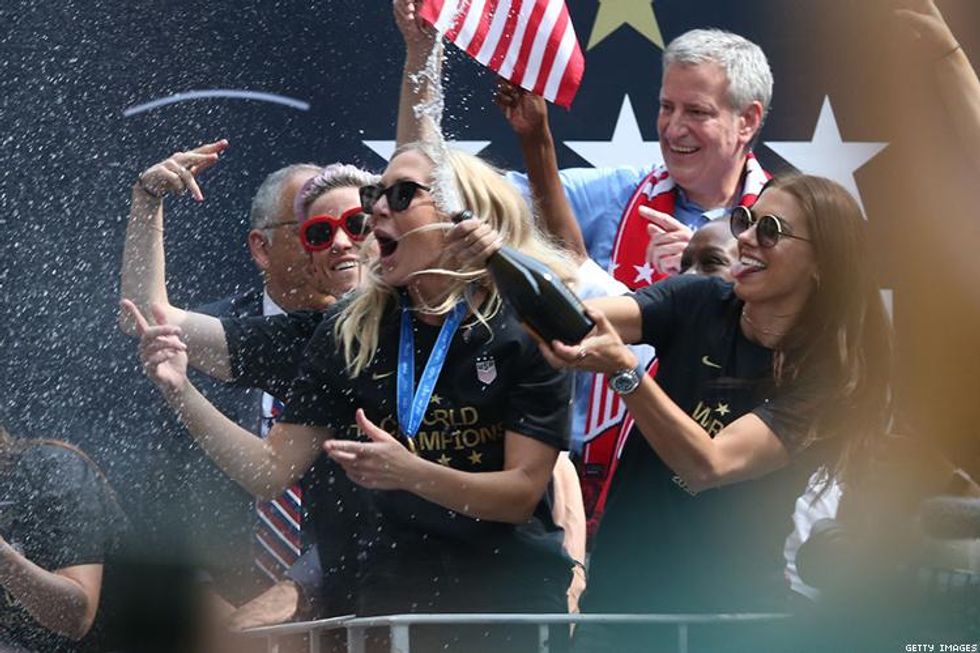 Alex Morgan sprays champagne while teammates Allie Long and Megan Rapinoe get the crowd pumped,