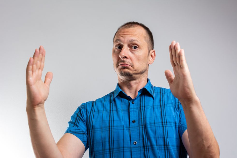 Amazed man look at camera show with hands large size feels shocked pose on grey wall, great offer big discount or ad of treatment penis enlargement increase length method and effectiveness