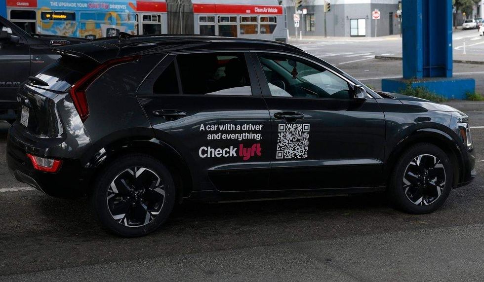 an SUV with the writing 'a car with a driver and everything. check lyft' on the side.