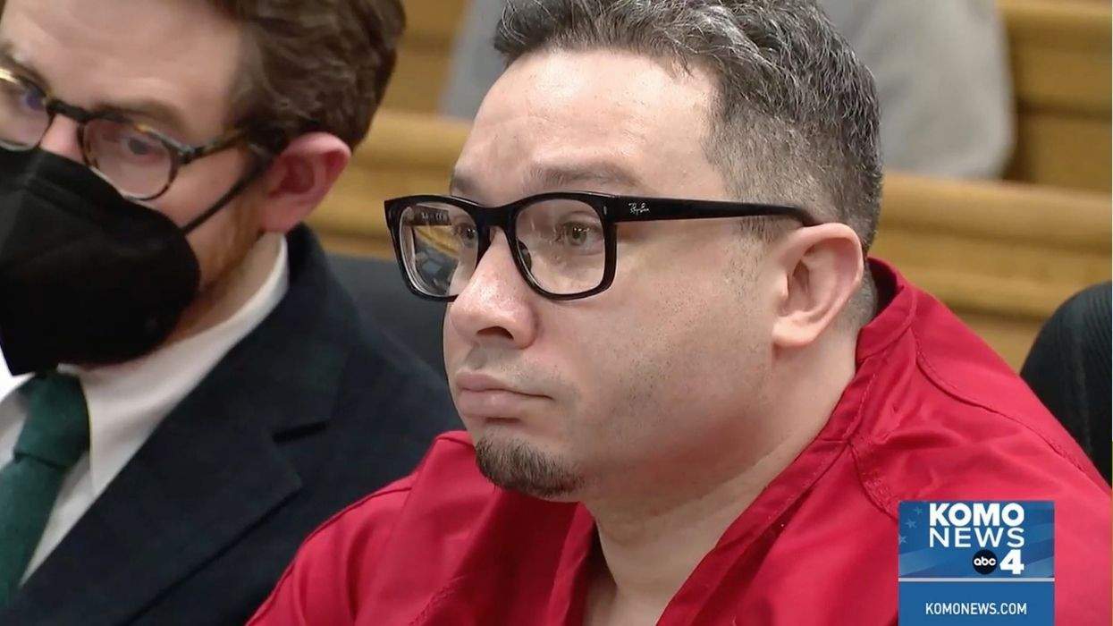 andre karlow wearing glasses and a red jail jump suit