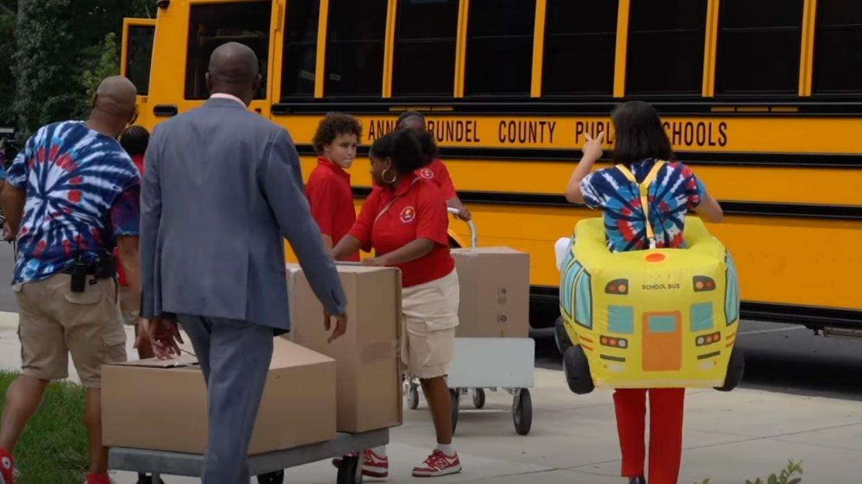 anne arundel county public school bus with kids and adults walking near it