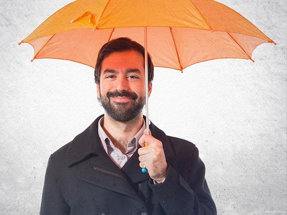 bearded man holding an orange umbrella
