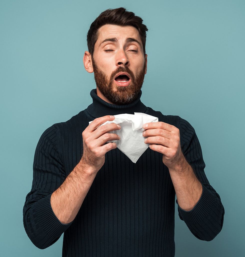 bearded man in turtleneck about to sneeze