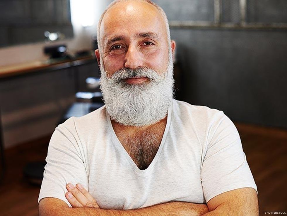 bearded man in white vneck with arms crossed