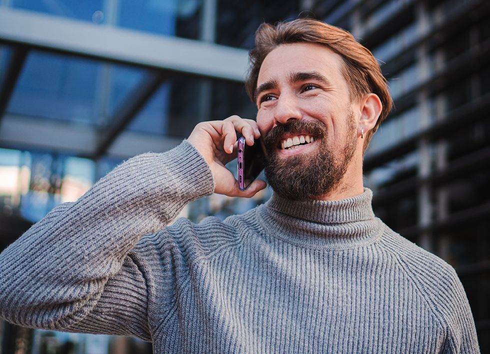 bearded man on cell phone smiling