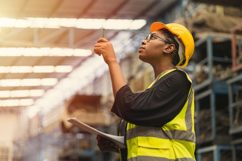 Black woman working with hard hat and vest