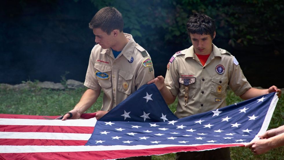 boy scouts folding a flag