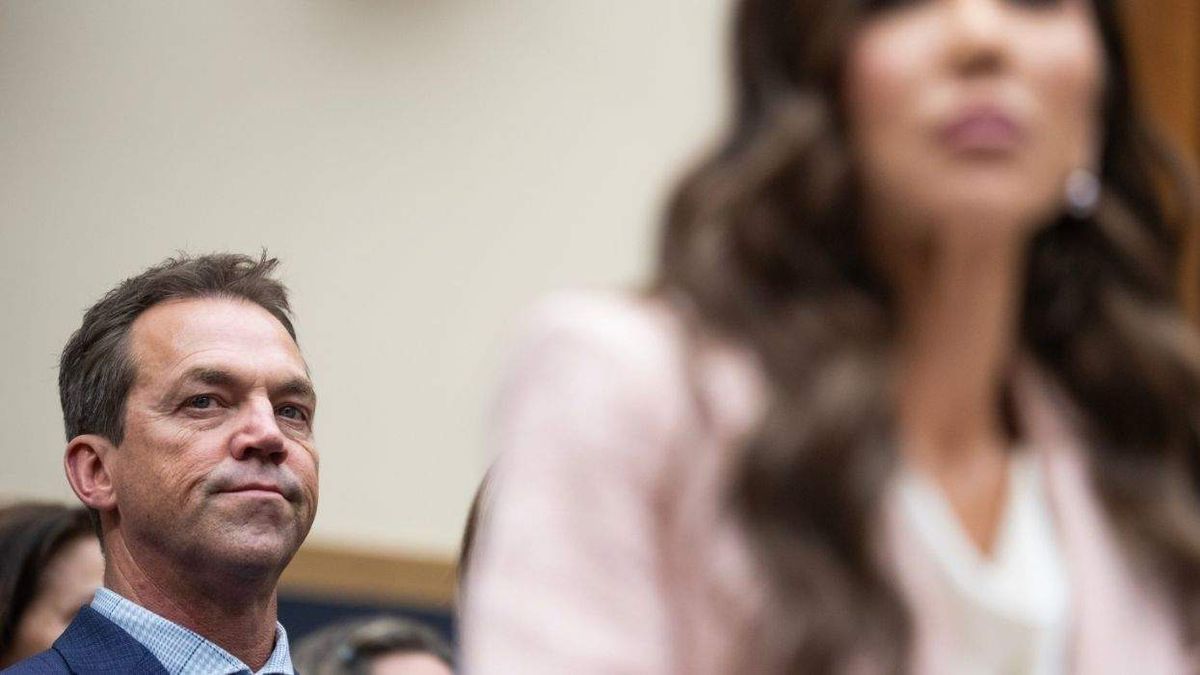 Bryon Noem sits behind his wife former DHS Secretary Kristi Noem during a public appearance