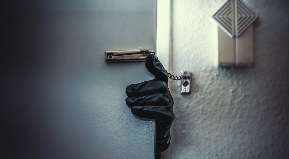 Burglar hand undoing apartment door lock