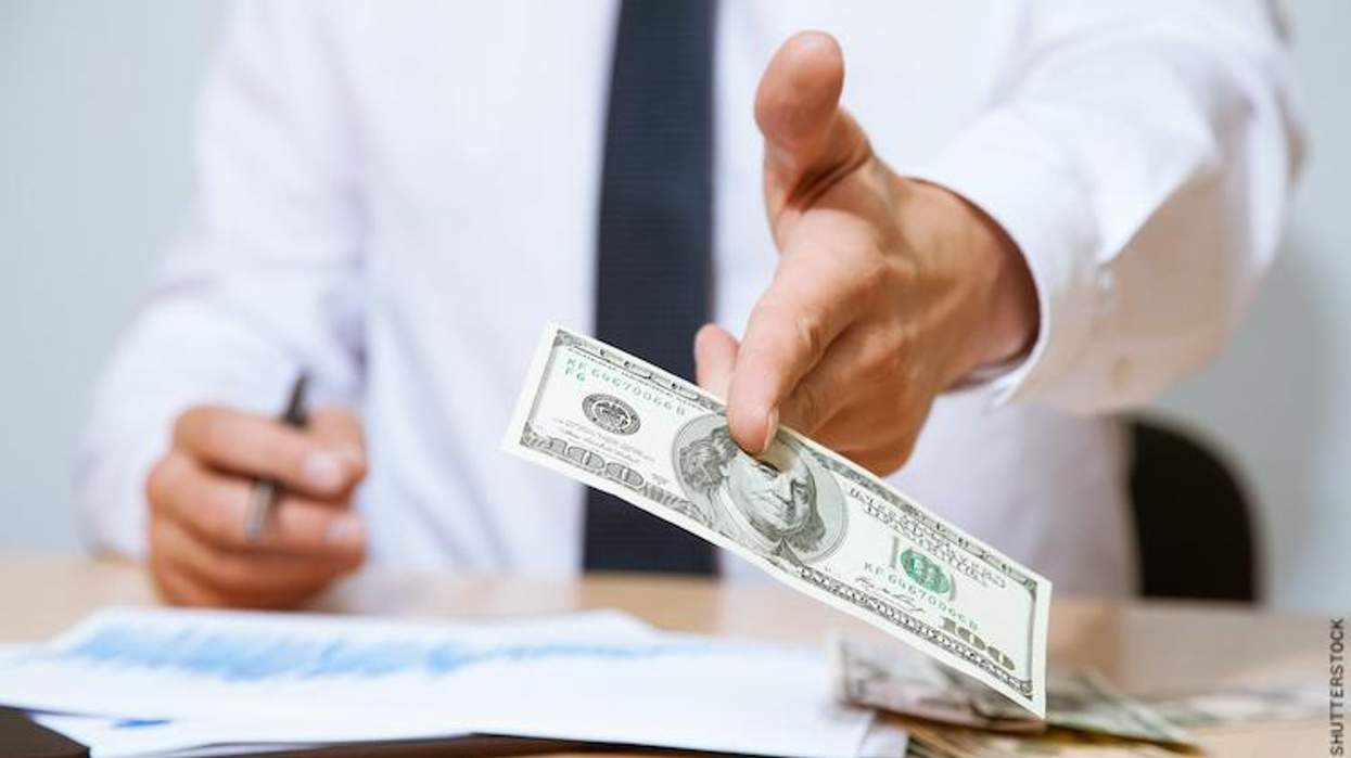 Business man handing over money.