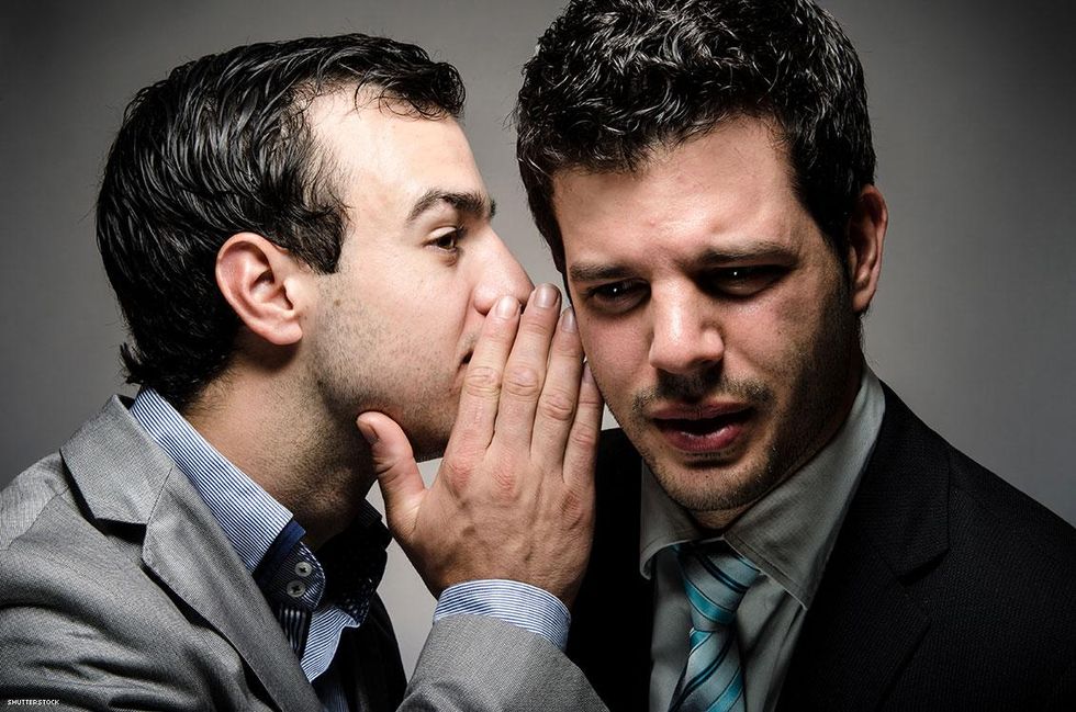 business man whispering in coworker ear
