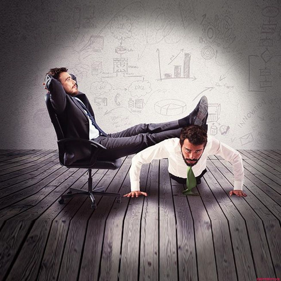 business man with feet on someone doing a pushup