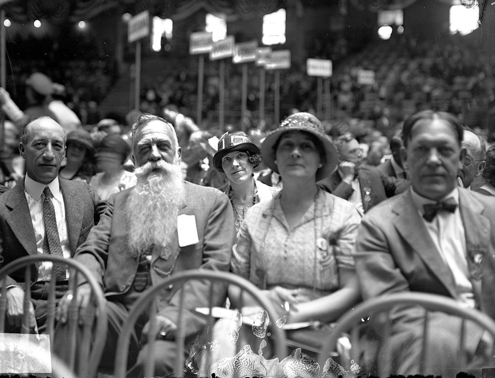 CB Wilson with big beard next to Mrs Curtis F Pike and Mrs SG Rich in the rear sitting in a row on the floor of Madison Square Garden during the Democratic National Convention NYC New York 1924