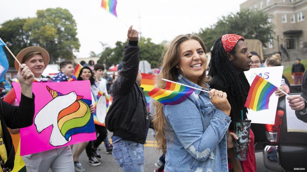 Celebratory people with LGBTQ+ pride flags