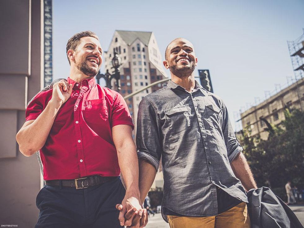 city men holding hands on a walk